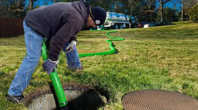 Service technician performing residential septic pumping and drainage maintenance in Nashua, NH